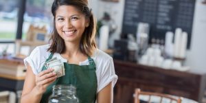 Image of employee of coffee shop holding tips